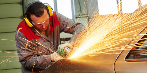 Grinding a weld on a car