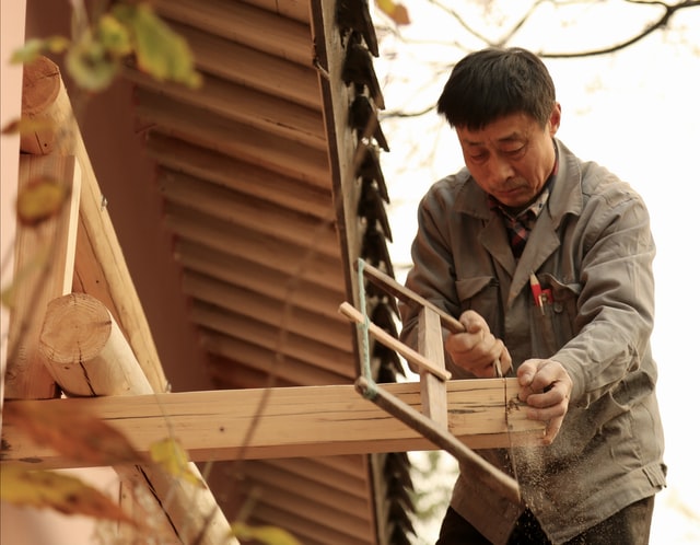 a man cutting wood with a frame saw