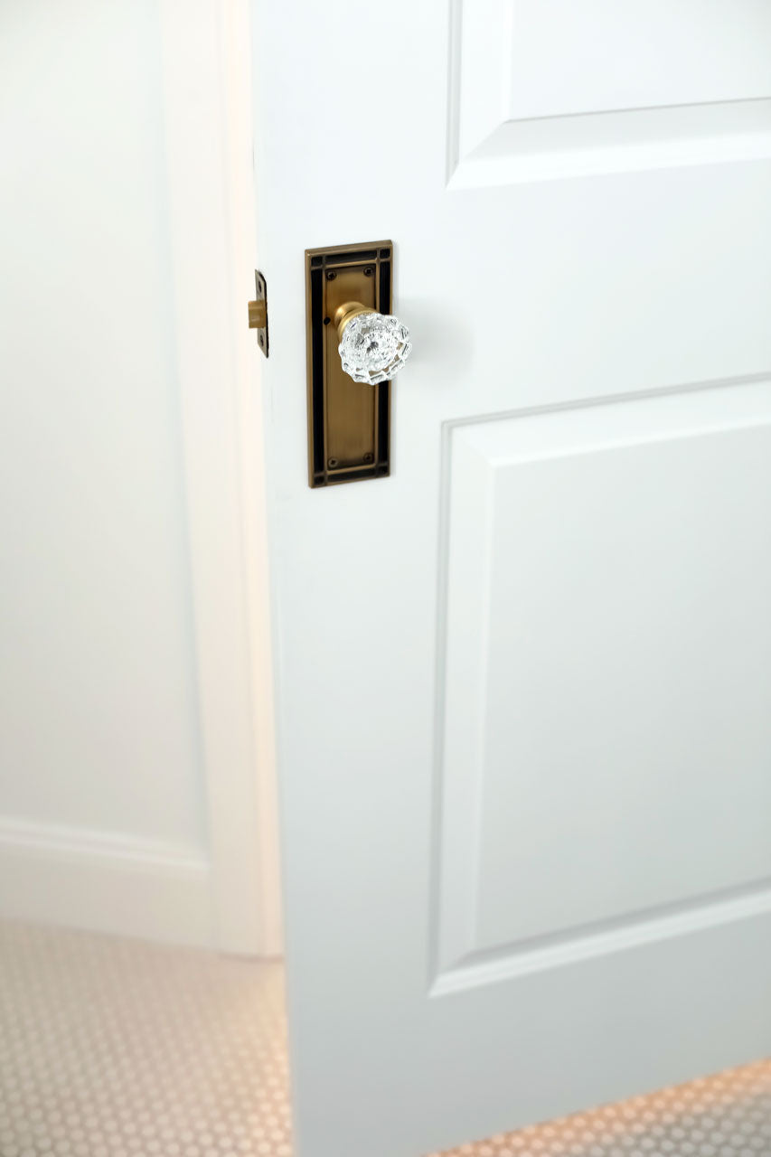 Mal Robison panel door with antique brass craftsman style door hardware and crystal door knob