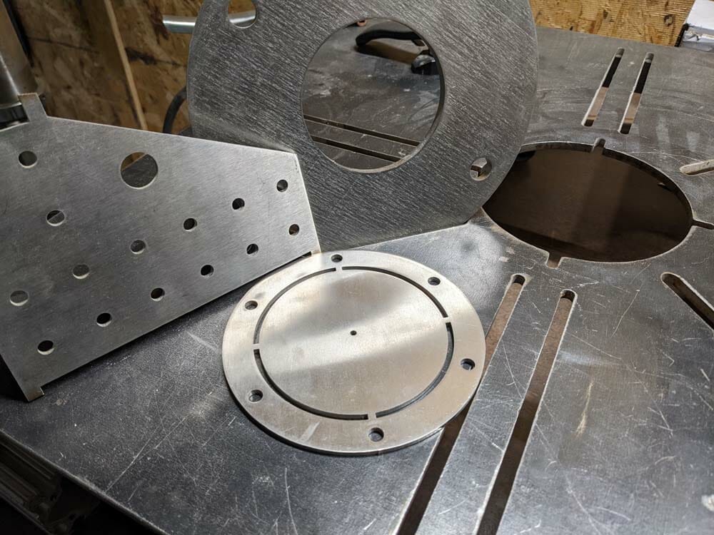 Image of three different laser cut parts in 304 stainless steel, prepped for welding